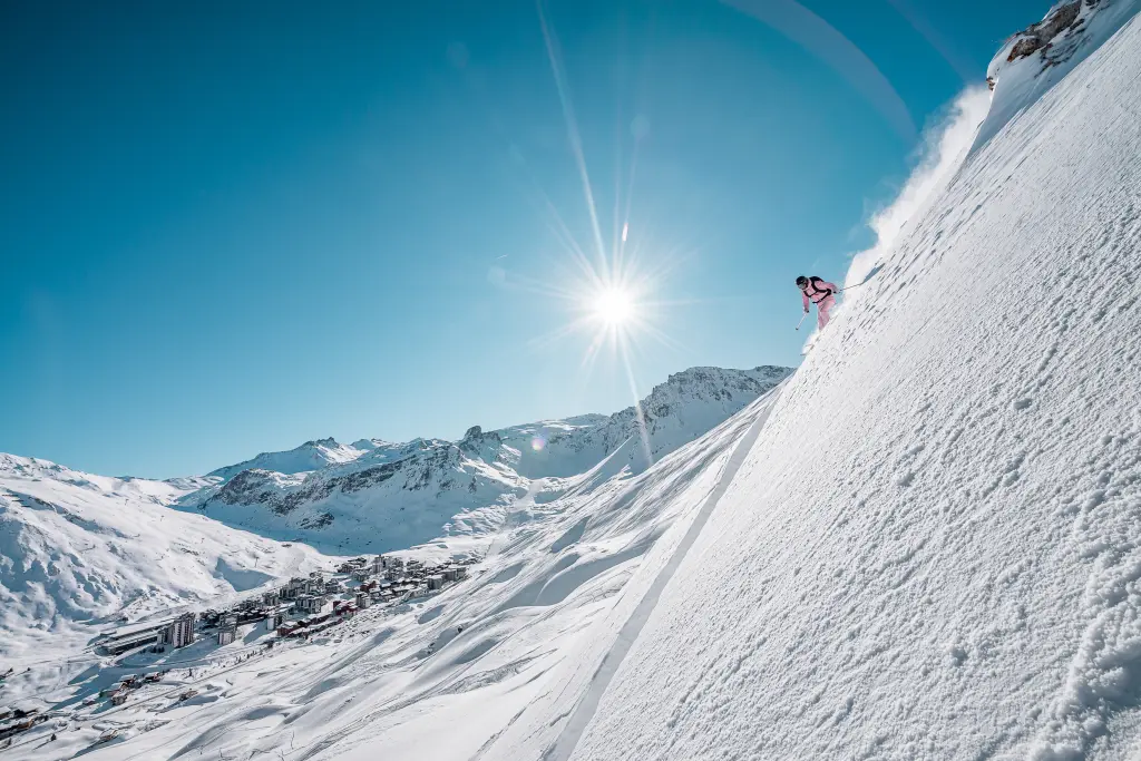 skieur sur le flanc d'une montagne avec vue sur le village de tignes