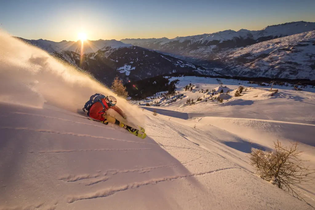 skieur sur les pistes au coucher de soleil