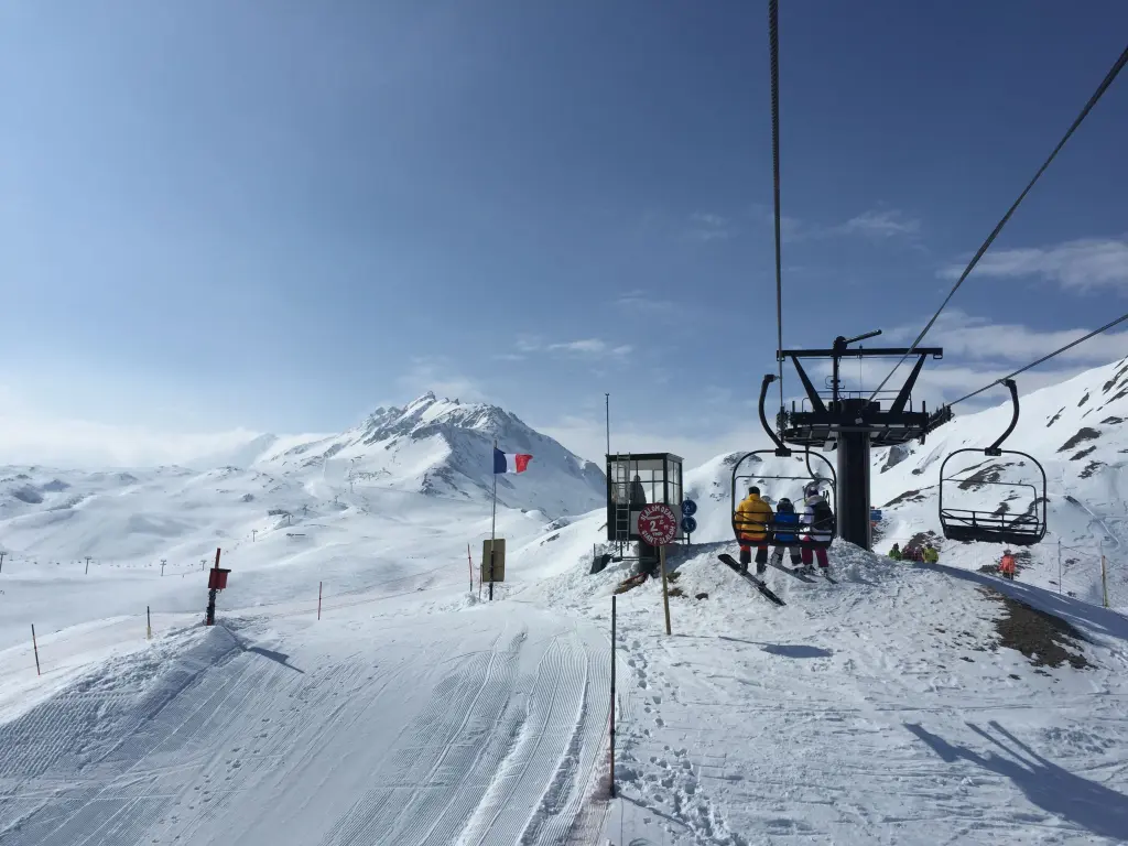 Vue panoramique d'une remontée mécanique à Tignes, dans les Alpes françaises, avec des skieurs en hiver.